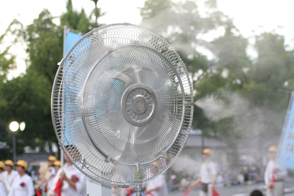 Ventilador nebulizador lanzando una fina niebla de agua durante un festival al aire libre