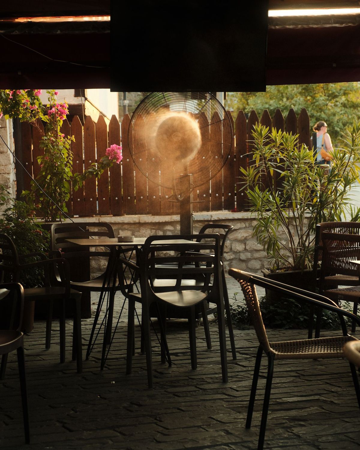 Ventilador nebulizador refrescando la terraza de un café al atardecer