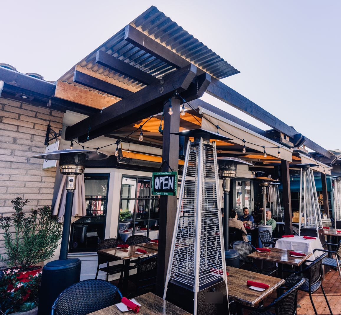 Terraza de restaurante con estufas de gas piramidales entre las mesas